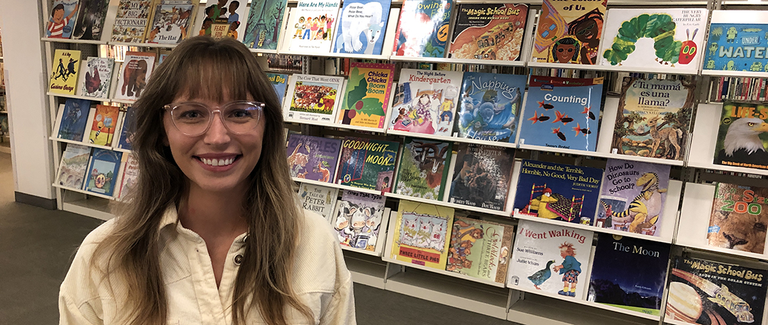 Alumna Taylor Petersen works inside the Teacher Resource Center in the campus library.
