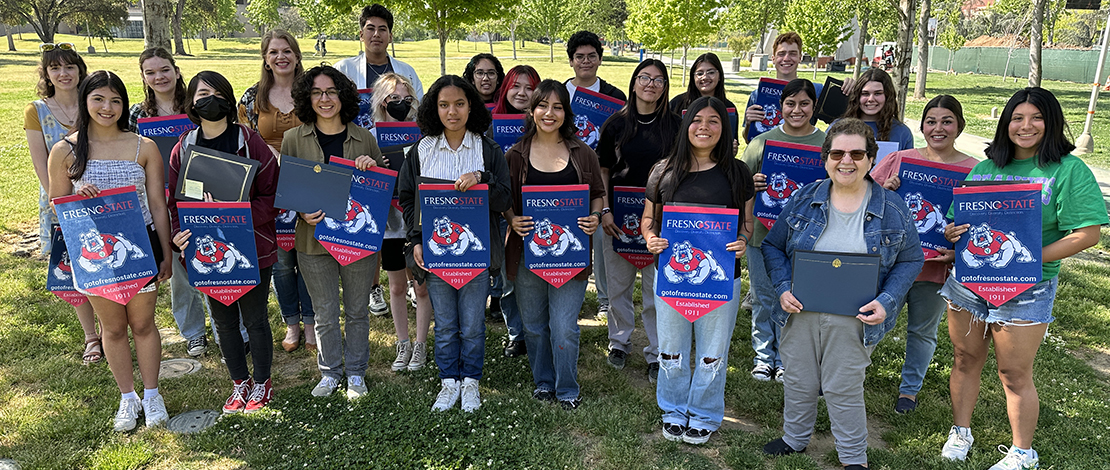group photo of 2023 award winners, holding fresno state posters
