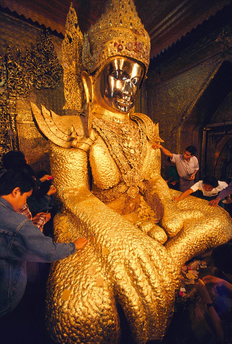 Image of people touching a golden Budda