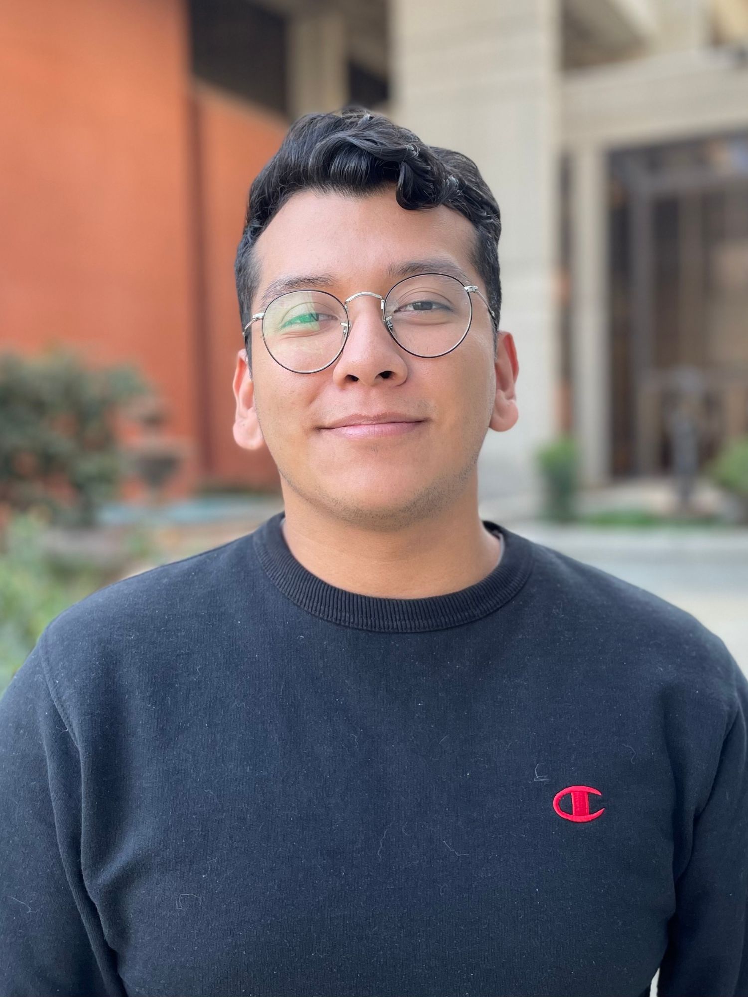 Marcos Rosas wearing a dark colored sweater outside Fresno State's Library